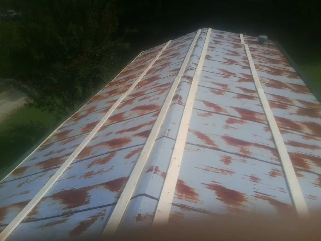Rusted metal roof panels with new wood purlins before replacement — Storm Damage Roof Repair in Urbana by Roofing Brothers