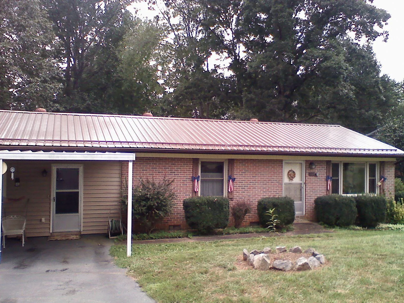 Bronze metal roof and carport on a brick ranch home — Roof Repair work by our crew in Urbana